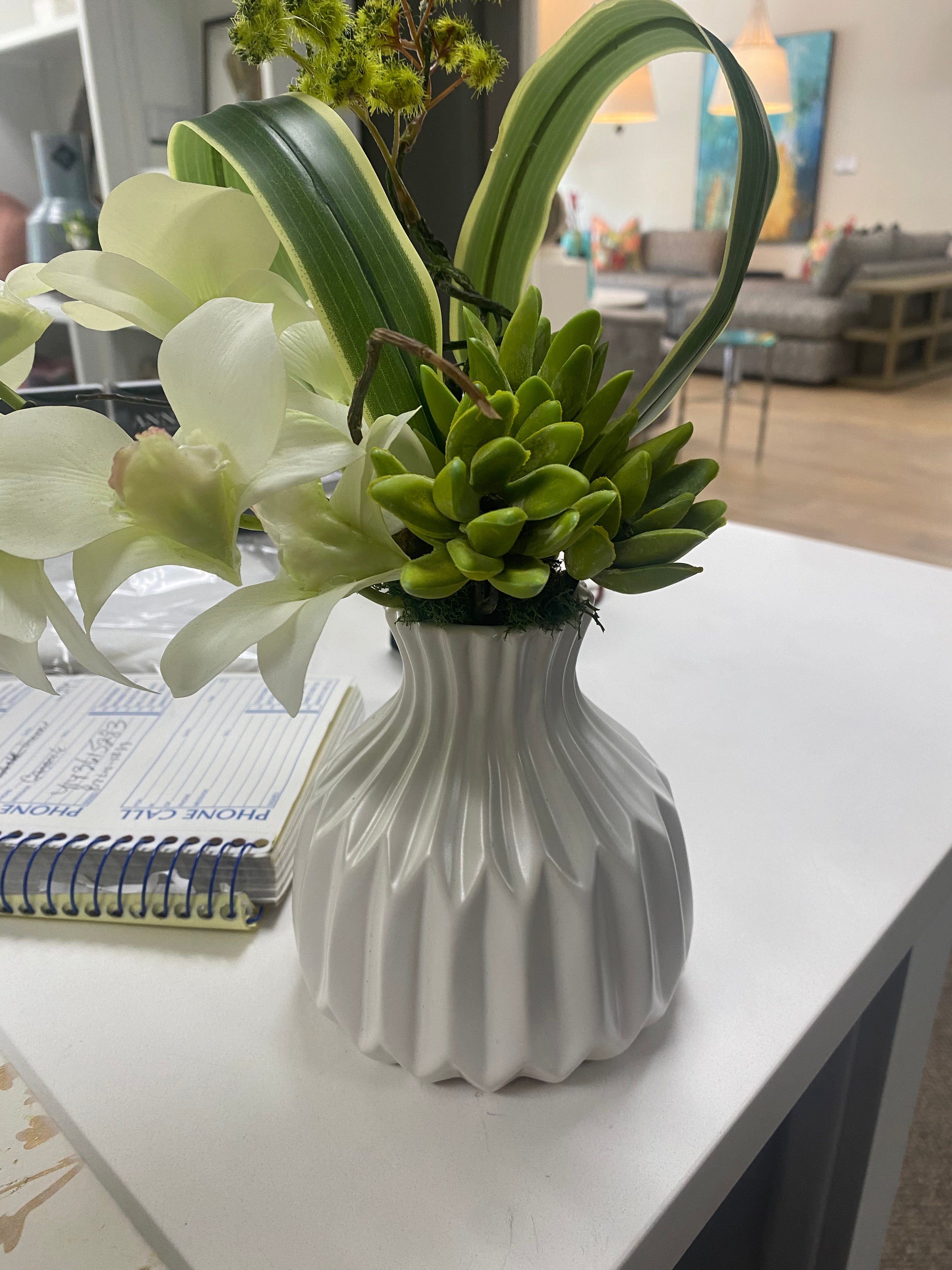 Small orchid in white vase